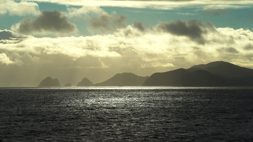 Stunning sunrise at sea. In the background, coastline of New Zealand