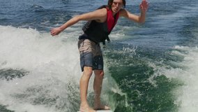 Medium slow motion high angle shot of wake surfer doing tricks / Lake Powell, Utah, United States