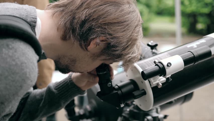 The man work with the spyglass on a tripod outdoor