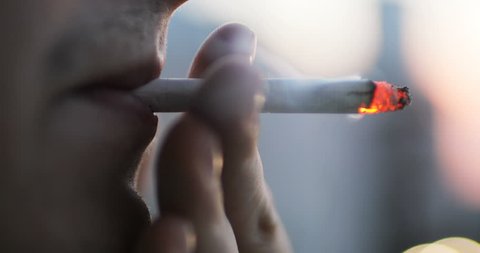 young man smoking a cigarette outdoor close-up. smoke fire light. boy smokes. man's lips. addiction tobacco smoker poison