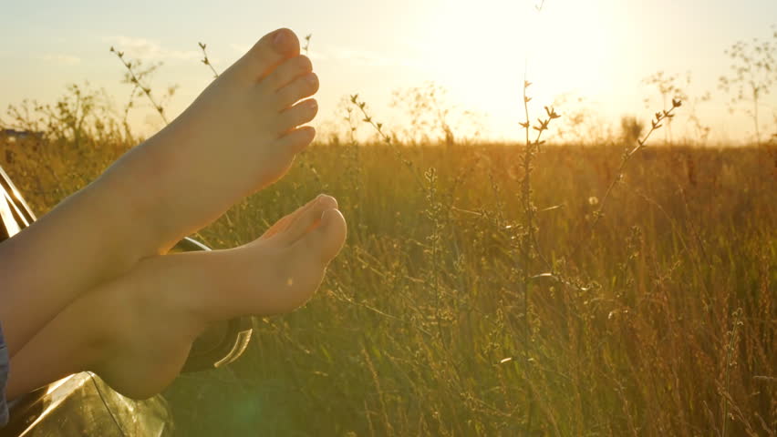 Woman legs out the windows in car . Conceptual freedom, travel and holidays image with copy space.
