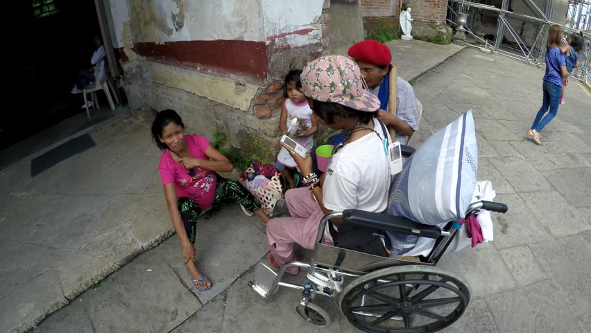 San Pablo City, Laguna, Philippines - July 6, 2017: Disabled Beggar, woman and children sitting at church portal that serve as their domicile