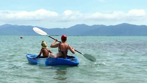 Mother and son kayaking at tropical sea
