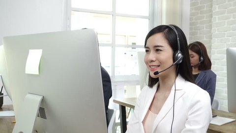 Asian business team working in call center as the operators (or telemarketers)
