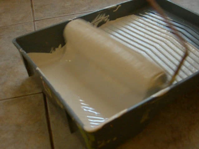 Paint roller being loaded closeup