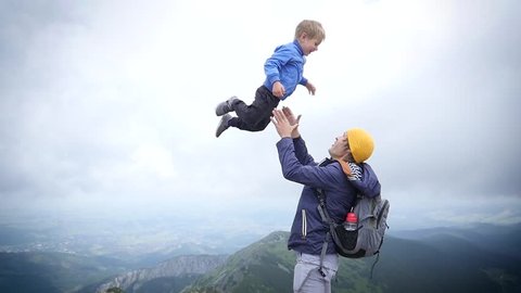 Young Father Playfully Throw Up In Air And Catch Little Child Son On Nature Hiking Walking Tatras Mountains