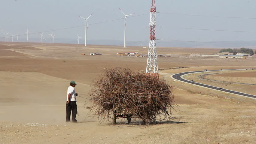 Rural scene with wind turbines & locals.