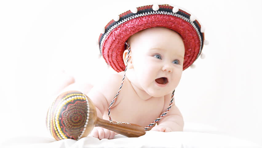 Baby in sombrero hat with maracas on the light background