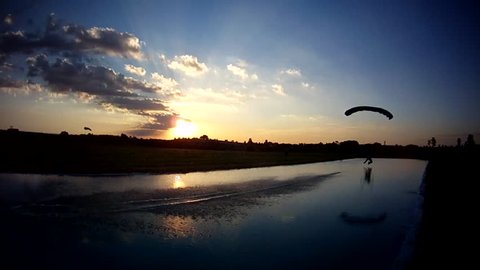 Skydive landing over lake at sunset