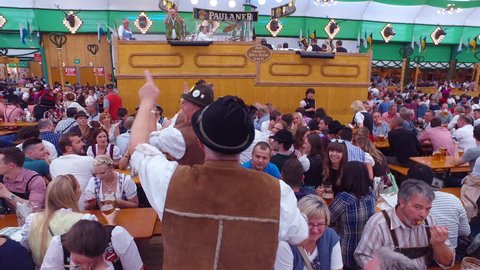 Munich, Germany-2010s: Drunken men celebrate and dance in a beer hall during Oktoberfest in Germany.