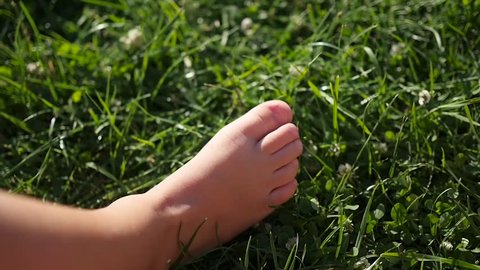 children's bare feet stomp across the grass. Fun outdoors