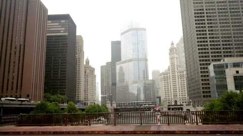 Brunette woman standing on chicago river bridge. Chicago skyline near river. Beautiful woman standing city river bridge. Modern cityscape in fog weather