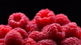 Raspberry rotation over black Background. Ripe fresh and juicy raspberries rotated close-up, isolated on black. Organic berry, healthy food. Diet, dieting 4K UHD video 3840X2160 