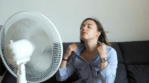 The video is about a young woman refreshing herself in front of a fan because of the summer heat