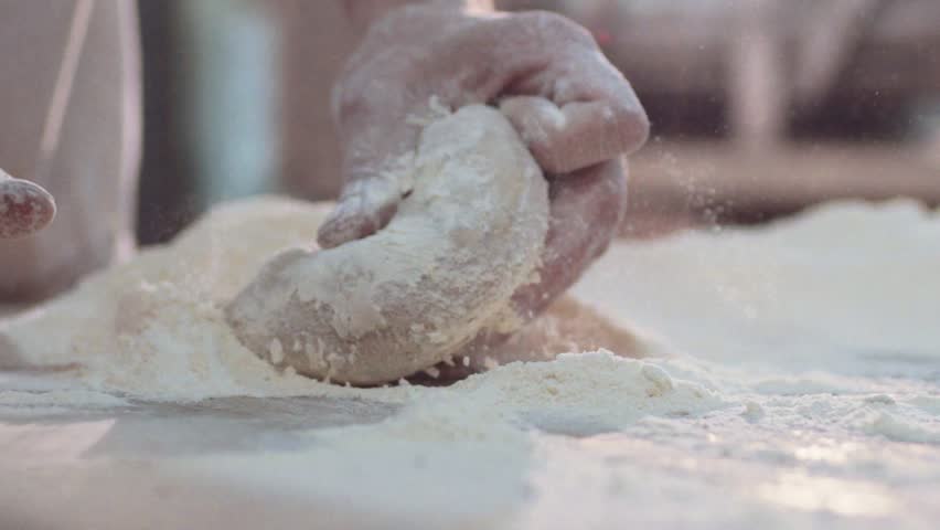 Close up view of married baker’s hands kneading the dough on the table. Manufacturing process, working hard. Making bread, bread production. Workplace. Beautiful view. Royalty-Free Stock Footage #28693684