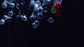 Raspberries, Blueberries and fresh mint leaves splashing into water on black background. Falling fresh fruits and berries in water. Organic berry, healthy food, diet 4K UHD video 3840X2160 slow motion