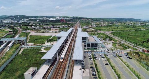 Aerial shot of THSR Miaoli Station with train passing by, this station is the Taiwan High Speed Rail located in Houlong Township, Miaoli County, Taiwan. 