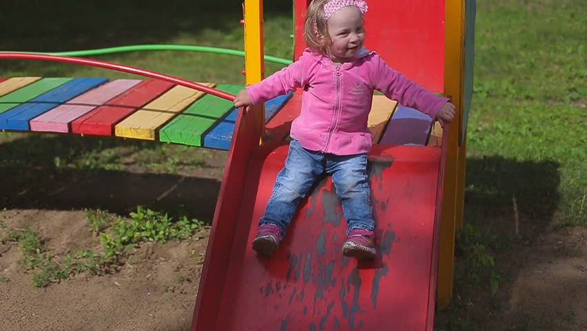 Little two year old blond girl in jeans plays in a children