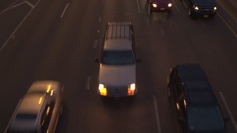 HIGH ANGLE, CLOSE UP, HYPERLAPSE: SUV, cars, vans & semi trucks driving along busy five lane freeway highway during the evening rush hour in Chicago. Travelers on road trip, people commuting by night