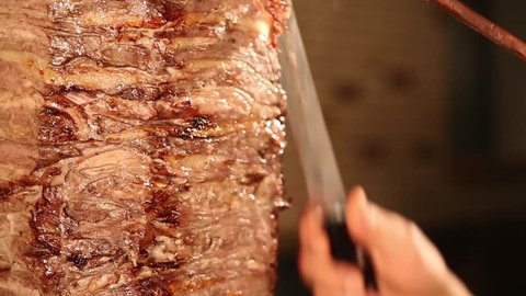 appetizing donner kebab cutting chef with tall knife, the most popular food in Turkey