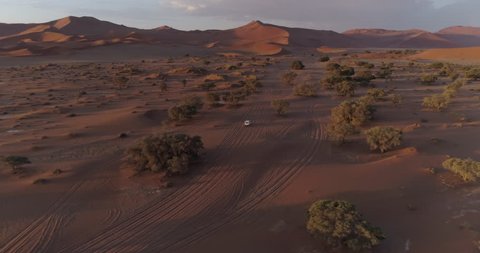 Aerial view of tourist vehicle driving through soft sand to Sossusvlei