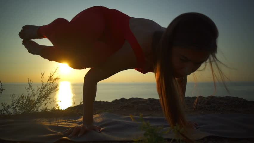 Silhouette young girl do yoga bacasana crane pose dawn coast rapid slow motion | Shutterstock HD Video #28711639