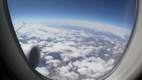 Aerial view of Europe out of an airplane window above the clouds with the earth shaped round through an fisheye view lens between Madrid and Frankfurt at daytime.