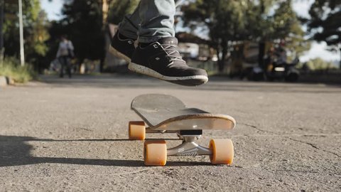 Boy Skateboarding Jump Lifestyle Hipster Concept, flip ollie trick, close up riding on longboard, skater start ride, skateboarder close up