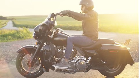 Stylish man on motorcycle in sunlight