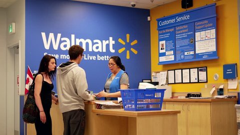 New Westminster, BC, Canada - July 03, 2017 : Motion of people returning goods at customer service counter inside Walmart store with 4k resolution