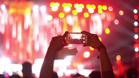 A person recording video with his phone in Club Show with crazy lights-
