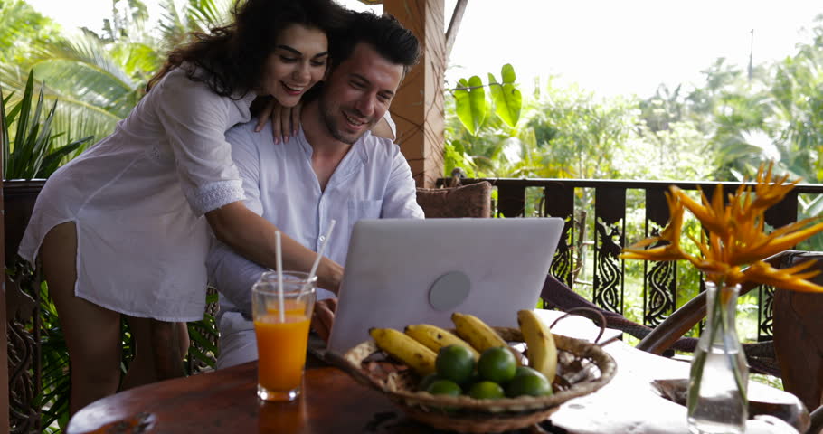 Young Couple Use Laptop Coputer Together On Terrace In Summer Forest, Beautiful Man And Woman Surfing Internet Talking Slow Motion 60