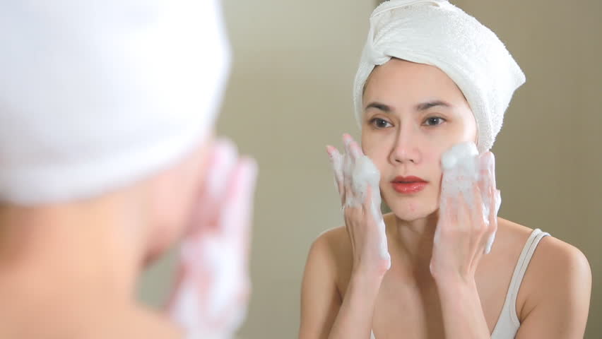Woman cleaning washing her face with foam in bathroom. | Shutterstock HD Video #28734406