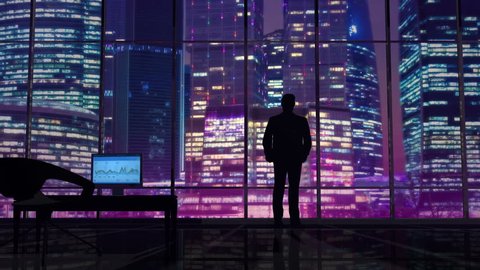 Businessman in an office on a background of night skyscrapers