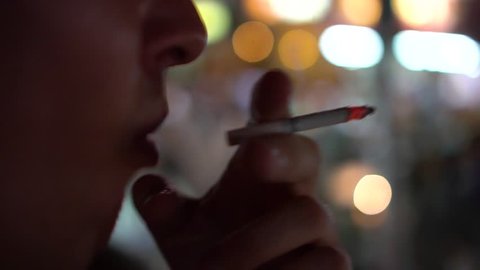 BANGKOK, THAILAND April 20, 2017: Close-up of a man smoking a cigarette at night.