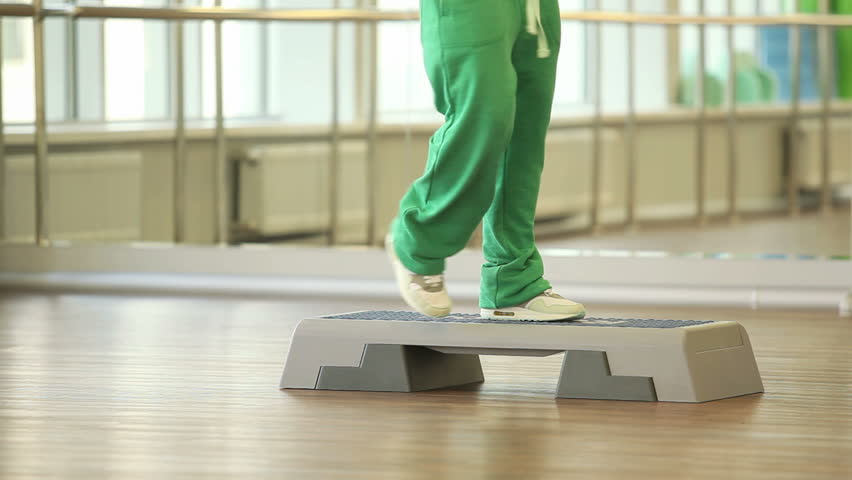 Woman training on step board in sport gym
