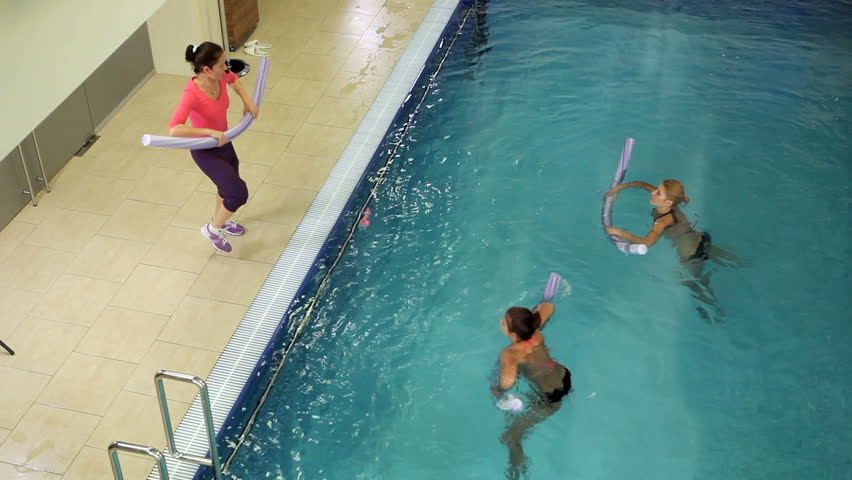 Instructor training women aqua gymnastic in swimming pool