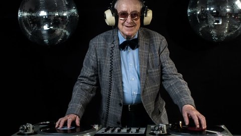 amazing DJ grandpa, older cool man djing and partying in a disco setting. these retired rockers will get the party going