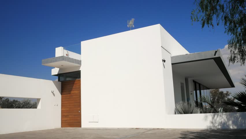 Handsome serious man in grey t-shirt opening the door with keys and entering his apartment.