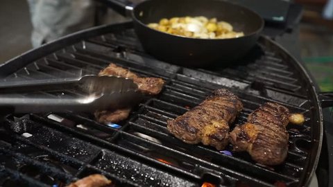 Grilling Beef Steak on flaming BBQ griller