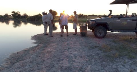 Aerial view of Tourists and guides enjoying a sundowner at the rivers edge in the Okavango  Delta at sunset