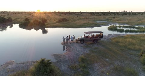 Aerial view of Tourists and guides enjoying a sundowner at the rivers edge in the Okavango  Delta at sunset