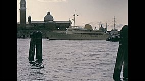 Big cruise boat sailing on Giudecca canal in front of the San Giorgio Maggiore church from port view. Historical archive footage on 60s, circa June 1967 from Venice city in Italy.