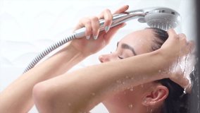 Woman taking shower. Young beautiful woman taking a shower and gently touching her skin, washing head. Skin care, beauty concept. Slow motion 240 fps. 4K UHD video.