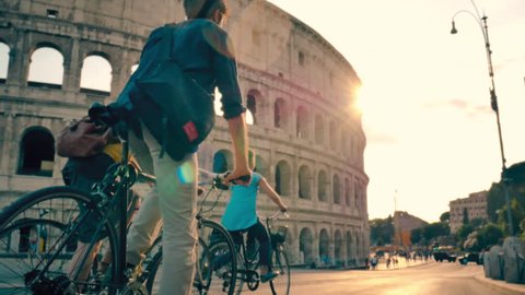 Tourist Friends with bicycles riding in front of Colosseum in Rome