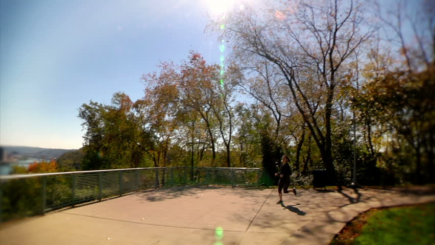 A young woman jogs at the West End Overlook in Pittsburgh on a sunny Autumn day.
