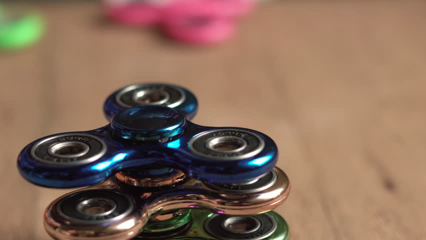 Set of rotatting colored fidget spinners stress relieving toys on wooden background