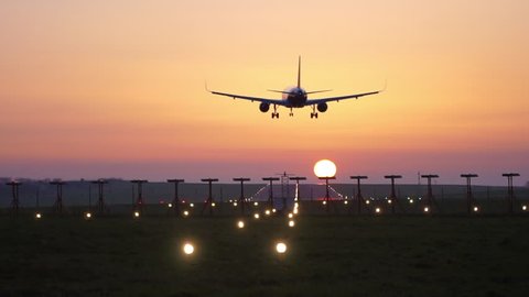 Airplane Landing on Airport Runway at Sunset, Beautiful Golden Sky & Jet Plane Silhouette