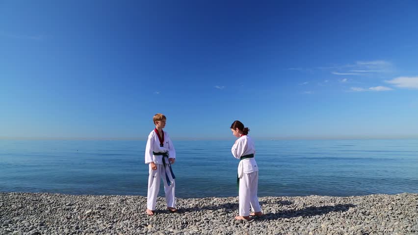 The education of the two children on the beach: Taekwondo, sport, sparring