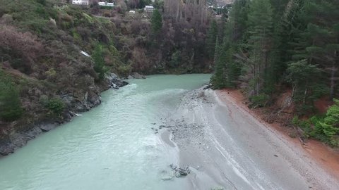 Drone aerial shot over the Shotover River as a speedboat rushes underneath